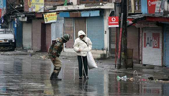 A security personnel helps a visually impaired man