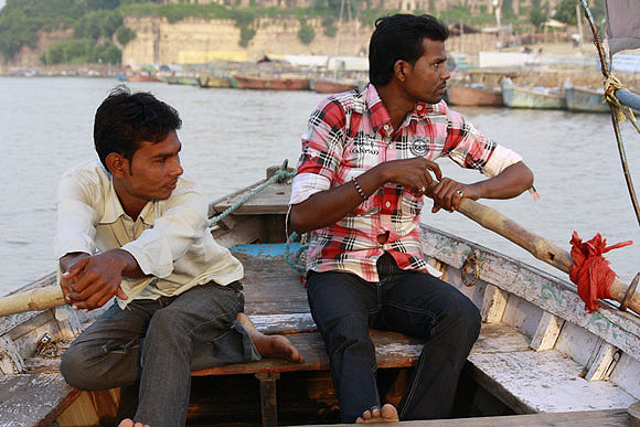Ashish and Sanjay Nishad row a hired boat and hope to make good business during the Maha Kumbh