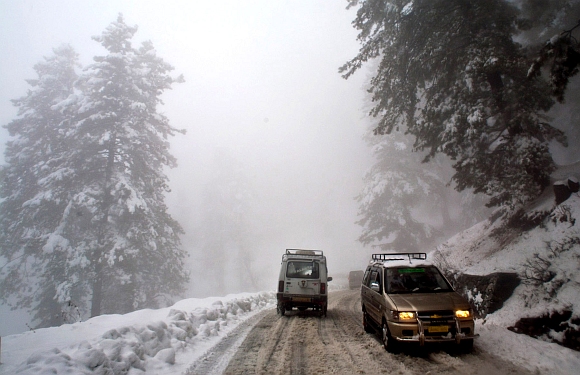 Vehicles pass through snow on the Gulmarg-Tangmarg road