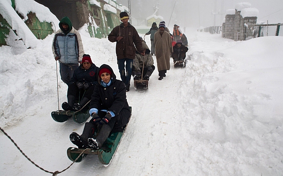 Tourists enjoy a sledge ride at Gulmarg