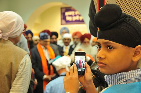 Jasbir, the son of Sita Singh, a priest killed in the attack, shoots photos of Krishna during his speech