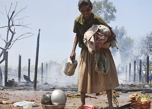 A Tamil refugee collects her belongings after a fire broke out in a camp in Vavuniya, northern Sri Lanka