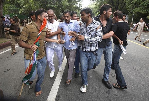 Arvind Kejriwal is shielded from the police by his supporters during a protest against corruption