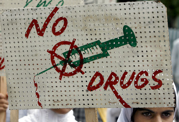A schoolgirl holds a placard during a protest against the use of drugs