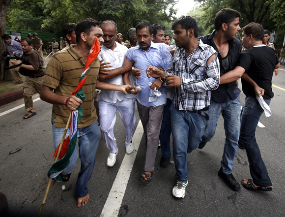 Arvind Kejriwal is shielded from the police by his supporters during a protest near Prime Minister Manmohan Singh's home