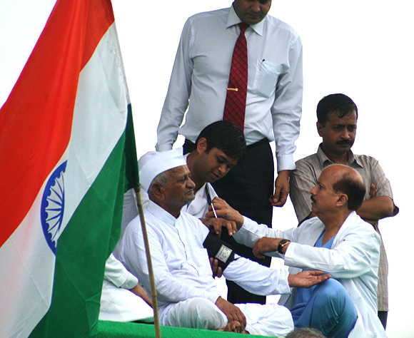 Doctors examine Anna Hazare at the Ramlila ground, New Delhi; Right: Arvind Kejriwal