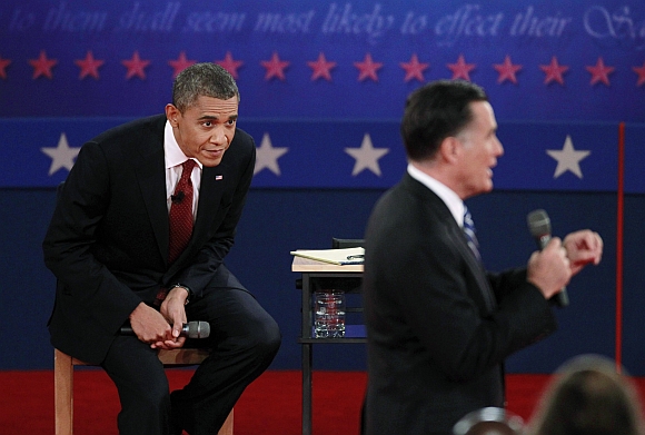 US President Barack Obama looks as Republican presidential nominee Mitt Romney speaks