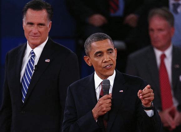 Republican presidential candidate Mitt Romney listens as US President Barack Obama answers a question during a town hall style debate at Hofstra University