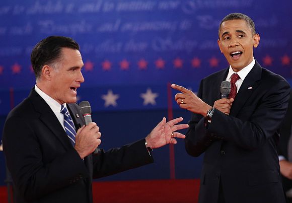 Republican presidential candidate Mitt Romney and US President Barack Obama talk over each other as they answer questions during a town hall style debate