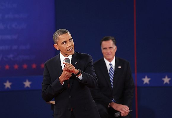 Republican presidential candidate Mitt Romney listens as US President Barack Obama answers a question