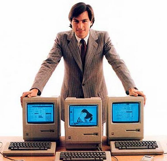 Steve Jobs poses with the 'beautiful device' called Macintosh