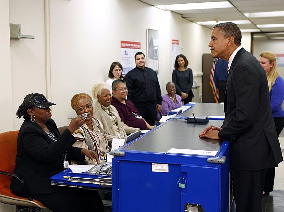 Polling workers double check the photo on US President Barack Obama's drivers licence