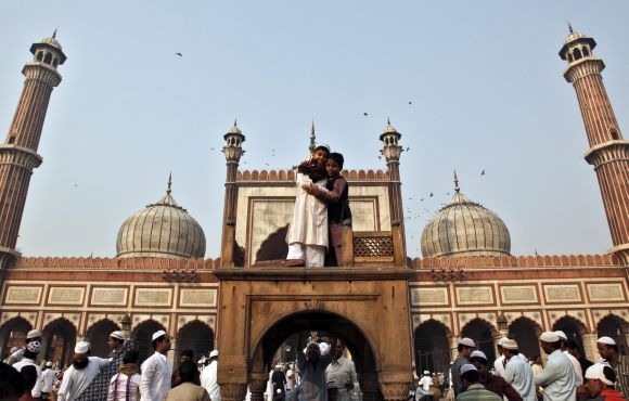 Muslim boys hug each other after performing Eid-ul-Azha prayers at the Jama Masjid in the old quarters of Delhi