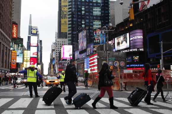 People pull their luggage at Times Square as Hurricane Sandy approaches New York