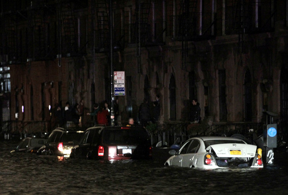 Flood waters brought on by Hurricane Sandy overrun cars in New York's lower east side