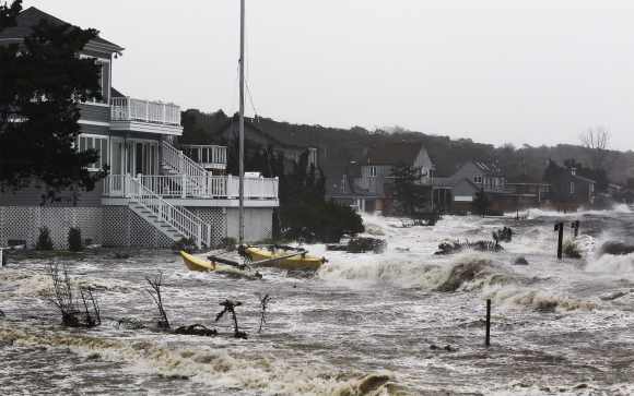 Storm surf kicked up by the high winds from Hurricane Sandy break onto homes in Southampton, New York