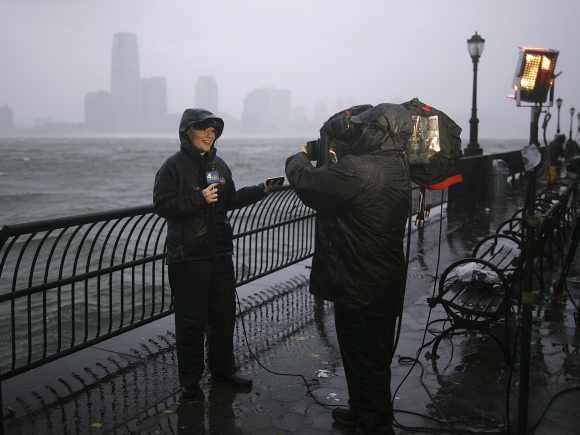 A reporter talks during a live report at New York Harbor as Hurricane Sandy approaches New York