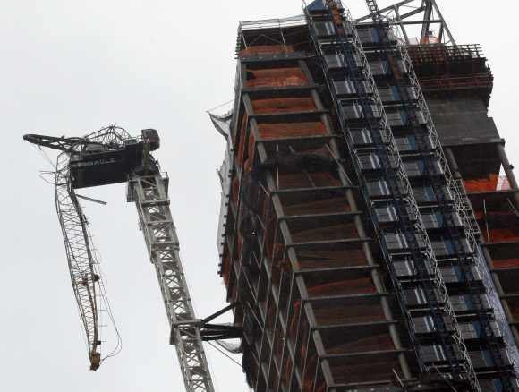 A partially collapsed crane hangs from a high-rise building in Manhattan