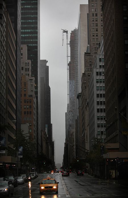 Part of a crane boom is seen hanging off a building under construction on West 57th Street in Manhattan, New York City