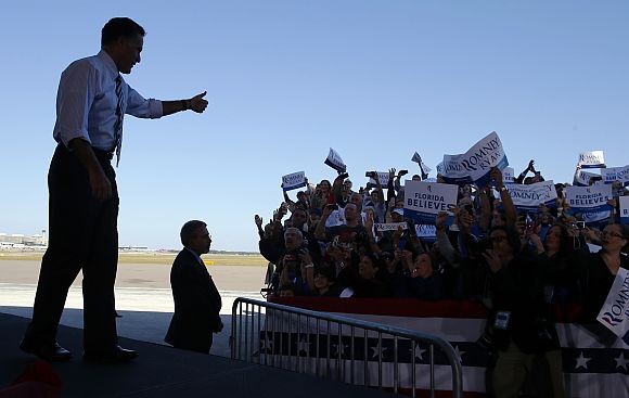 Romney gives a thumbs up to the cheering crowd as he takes the stage