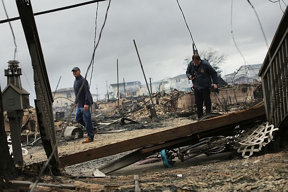 Fire inspectors walk through a neighborhood destroyed during Hurricane Sandy in the Breezy Point neighborhood of the Queens borough of New York City