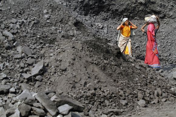Labourers carry coal at a stockyard of an underground coal mine in Odisha