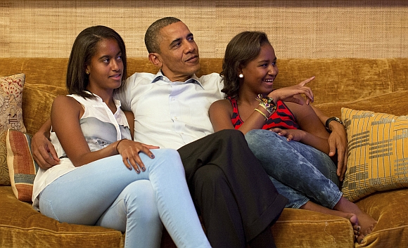 US President Barack Obama and his daughters Malia (left) and Sasha, watch on television as first lady Michelle Obama takes the stage to deliver her speech at the Democratic National Convention, in the Treaty Room of the White House in Washington September
