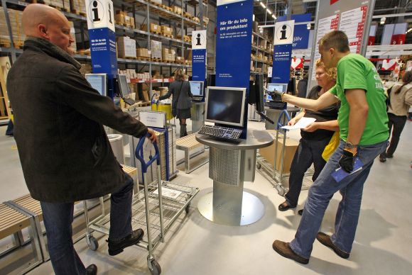 Customers check products on computer terminals at a store in Malmo, Sweden