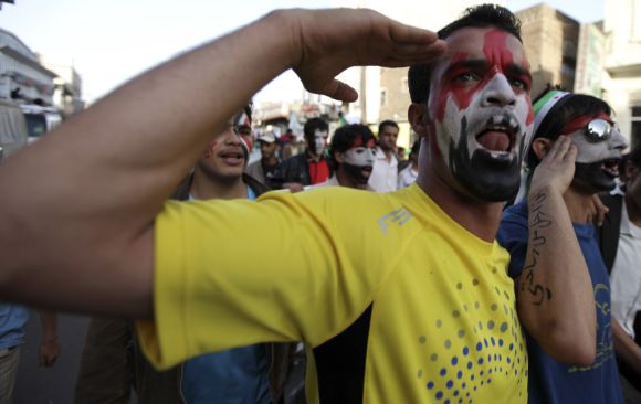 An anti-government protester gestures with the colours of the national flag of Yemen on his face during a demonstration in Sanaa.