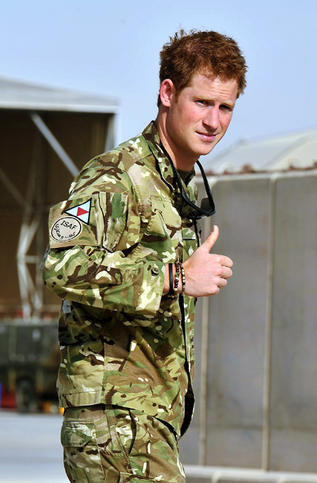 Britain's Prince Harry gestures after passing the Apache helicopter flight line at Camp Bastion, Afghanistan