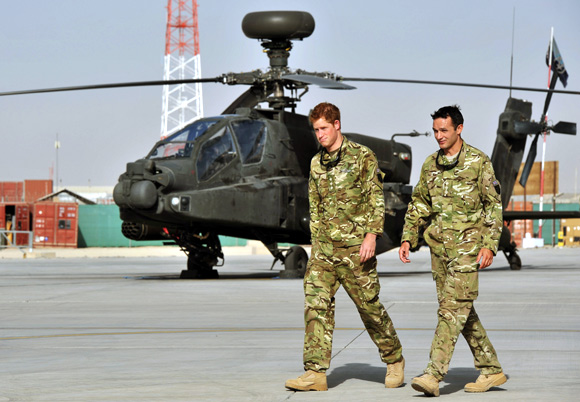 Prince Harry is shown the Apache helicopter flight line by an unidentified member of his squadron at Camp Bastion, Afghanistan