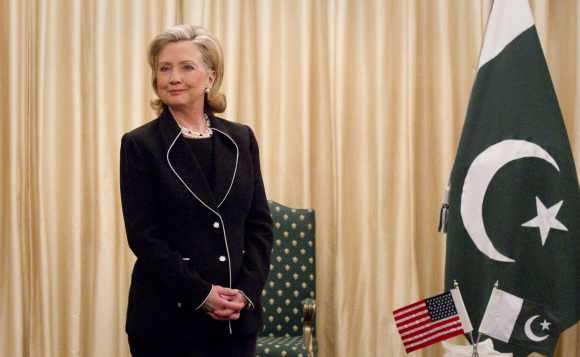 US Secretary of State Hillary Clinton stands next to the Pakistan national flag