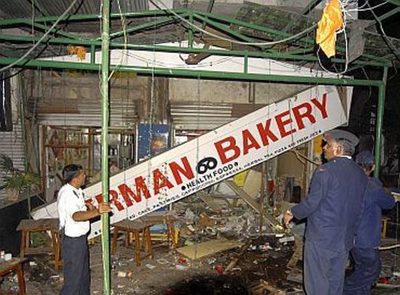 Firefighters examine the site of a bomb blast at the German Bakery restaurant in Pune on February 13, 2010
