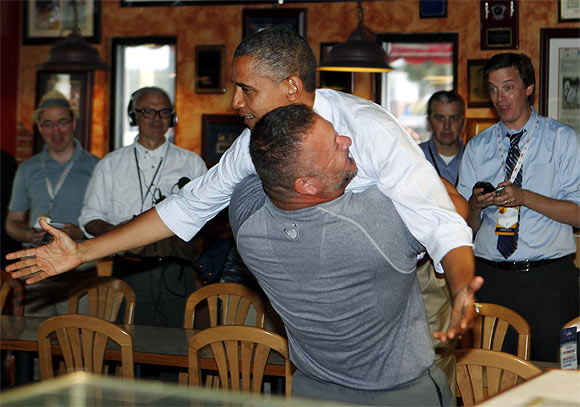 US President Barack Obama holds on as he is hugged and picked up by Scott Van Duzer at Big Apple Pizza and Pasta Italian Restaurant in Fort Pierce, Florida, while campaigning across the state by bus