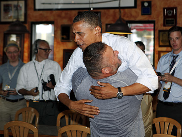 Obama holds on as he is hugged and picked up by Scott Van Duzer at Big Apple Pizza and Pasta Italian Restaurant