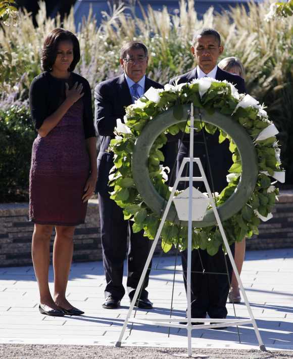 US President Barack Obama is joined by first lady Michelle Obama and US Secretary of Defence Leon Panetta as he lays a wreath during a memorial