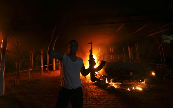 A protester reacts as the US consulate in Benghazi is seen in flames