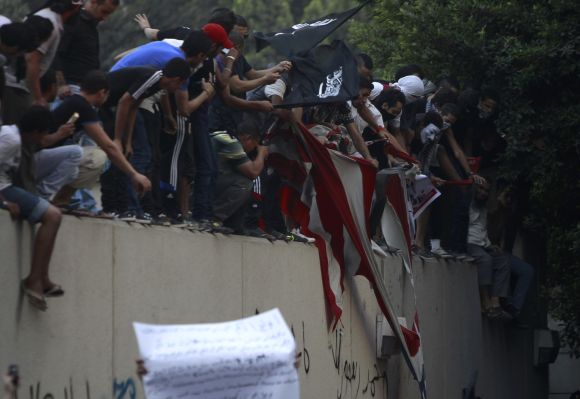 Protesters destroy an American flag pulled down from the US embassy in Cairo