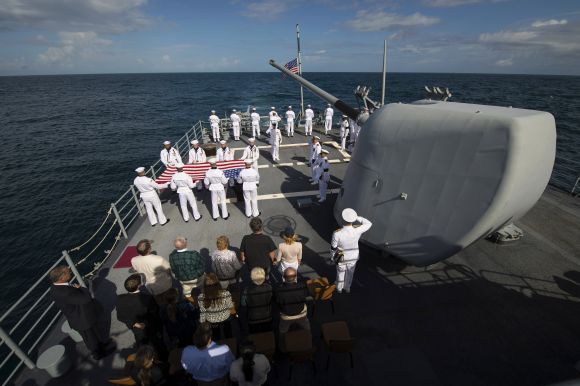 Family members of late Neil Armstrong and members of the US Navy are seen during the burial at sea service