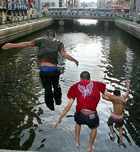 Japanese men jump into Osaka's Dotonbori River