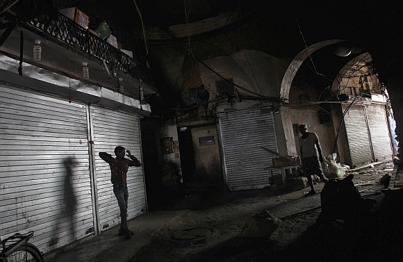 People walk past closed shops during a nationwide strike in the old quarters of Delhi