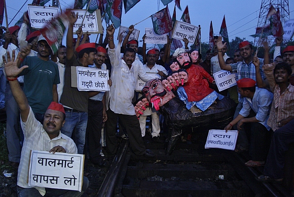 Demonstrators from the Samajwadi Party shout slogans as they gather around an effigy on a railway track during a protest against price hikes in fuel and foreign direct investment near Allahabad railway station
