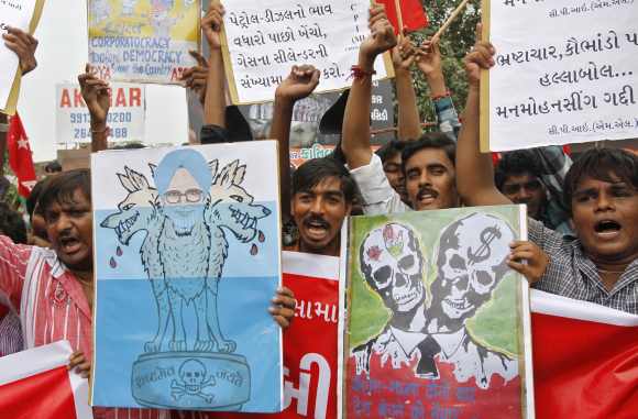 Protestors shout anti-government slogans and hold a caricature of Dr Singh during a nationwide strike