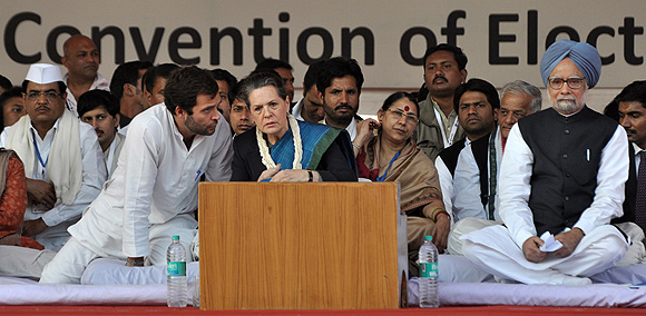 Sonia Gandhi listens to her son, Rahul, as Prime Minister Manmohan Singh looks on.