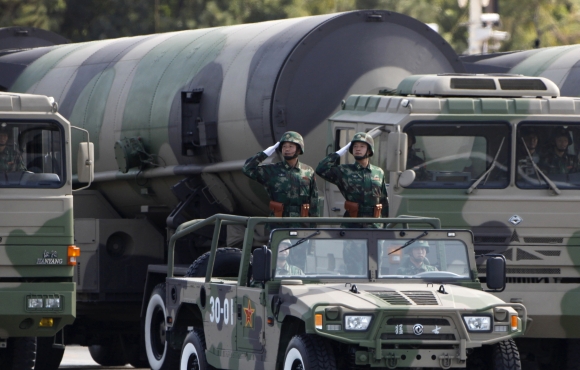 People's Liberation Army soldiers salute in front of nuclear-capable missiles during a massive parade in Beijing
