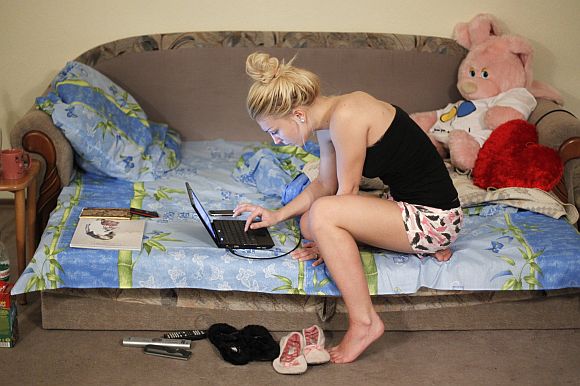 Femen activist Inna Shevchenko sits with her computer in an apartment in Kiev