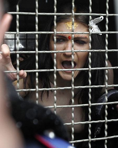 A detained activist from women's rights group Femen shouts from a police van