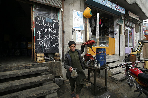 A boy sells petrol at a shop along a roadside in Quetta