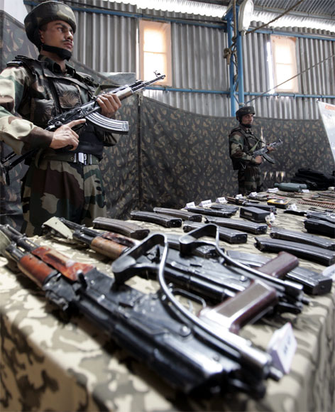 Soldiers stand guard near seized arms and ammunitions at an an army garrison in Kupwara, north of Srinagar
