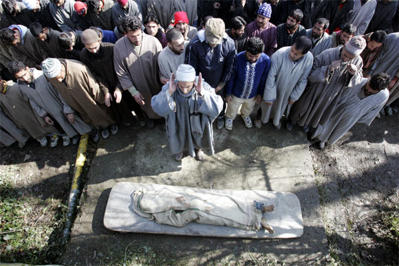 Villagers pray during the funeral of a militant in Sopore
